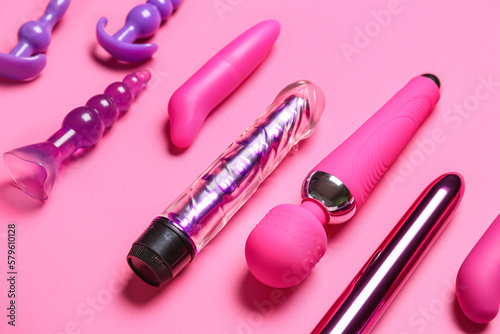Vibrators with anal plugs on pink background, closeup