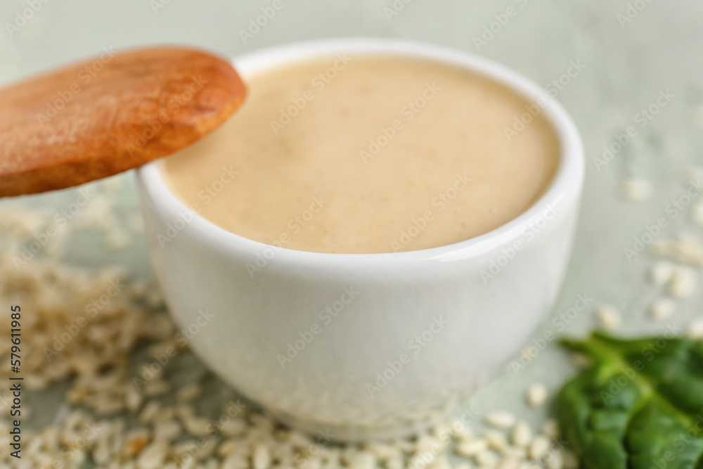 Bowl with tasty tahini on grunge background, closeup Bowl with tasty tahini on grunge background, closeup