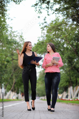 Fototapeta Naklejka Na Ścianę i Meble -  Business meeting of two girls in the park