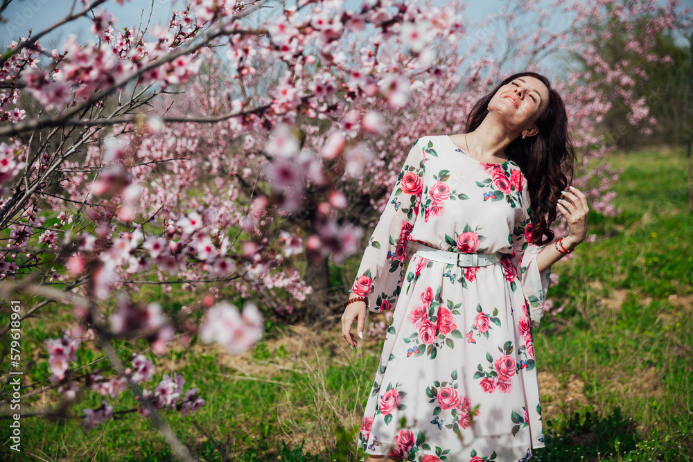 woman near pink flowering trees in peach garden nature spring woman near pink flowering trees in peach garden nature spring