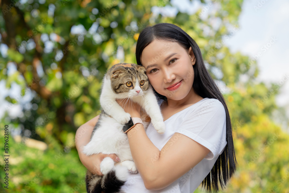 Asian woman holding a cat at the park
