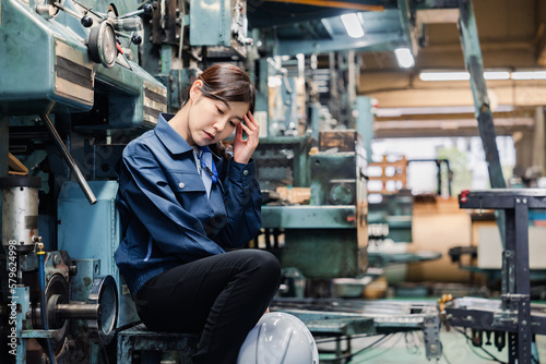 過労でやる気をなくす工場労働者の女性