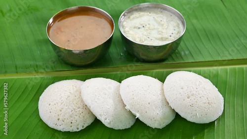 Serving South Indian breakfast Idli  with chutney and sambar.