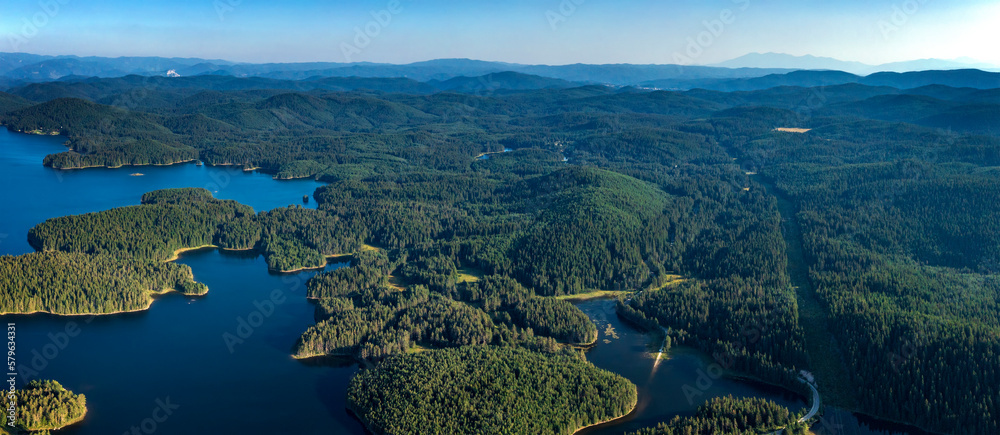 Aerial panorama from drone of blue water and green forest.