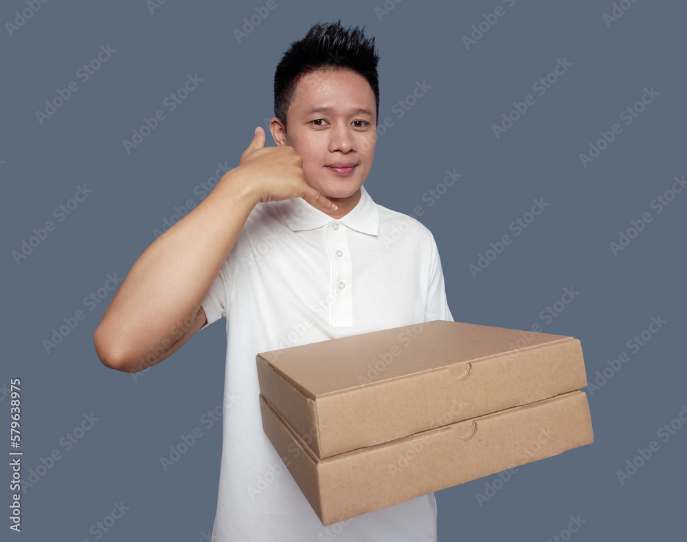 Man holding cardboard box with hand gesture making phone call. Man holding cardboard box with hand gesture making phone call.