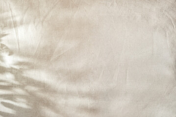 Abstarct floral natural background with foliage sunlight shadows on beige textile, copy space