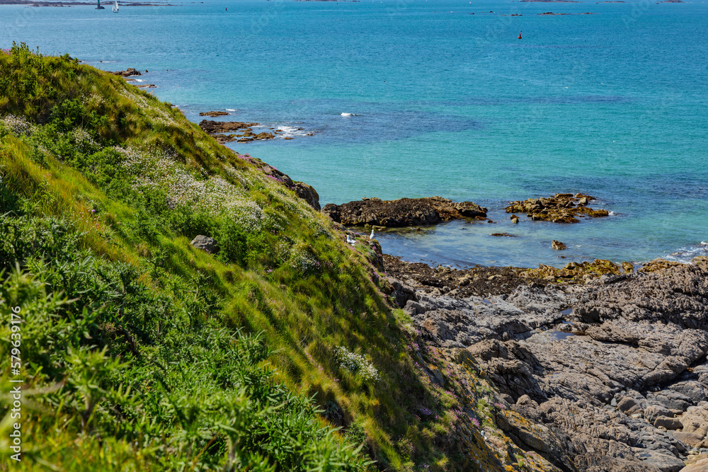beautiful view from the island towards the sea, small islets and a green slope, Saint Malo, France