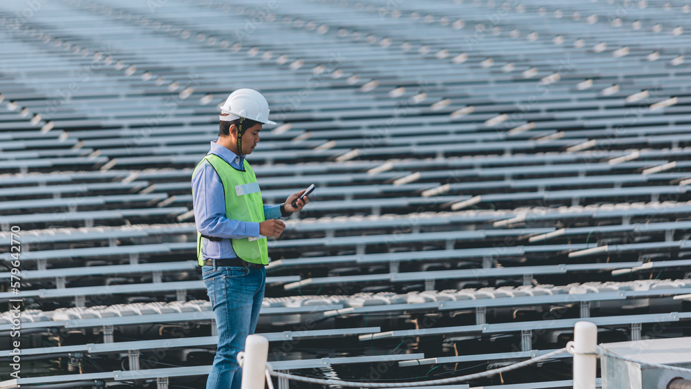 An young engineer is checking with tablet an operation of sun and cleanliness on field of photovoltaic solar panels on a sunset. Concept:renewable energy, technology,electricity,service, green,future An young engineer is checking with tablet an operation of sun and cleanliness on field of photovoltaic solar panels on a sunset. Concept:renewable energy, technology,electricity,service, green,future