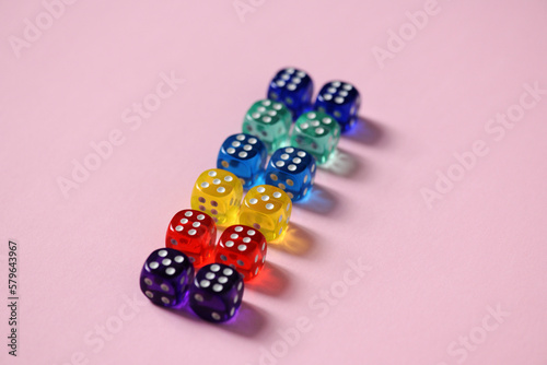 Close-up of colorful dice arranged over pink background photo