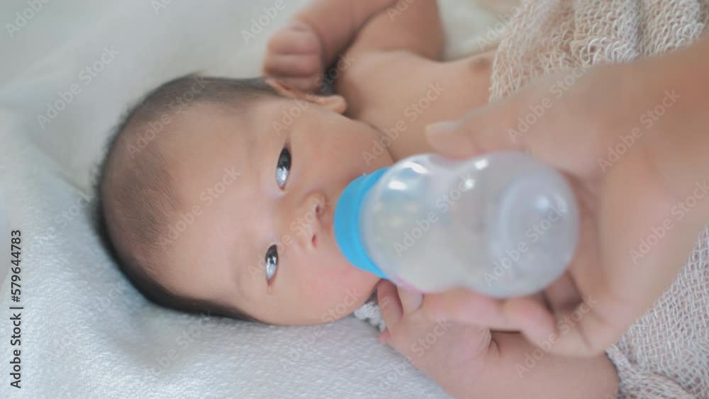 Mother bottle-feeding her newborn baby at home Mother bottle-feeding her newborn baby at home