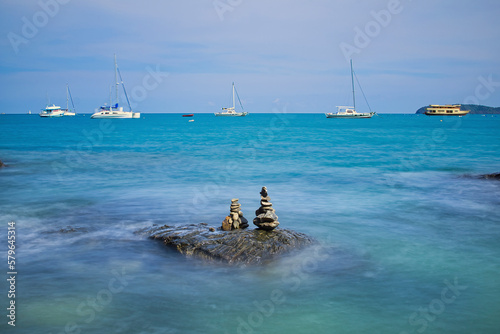 Scenic view of sea with stacked rocks against cloudy sky photo