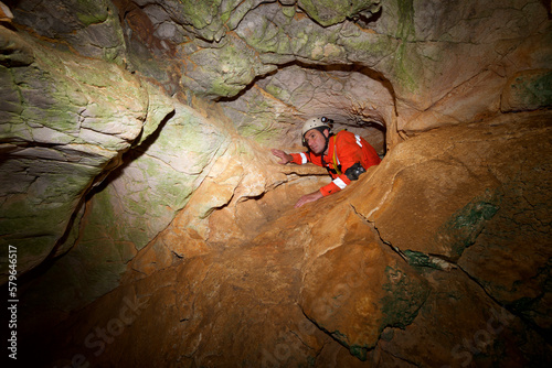 High angle view of man spelunking in rocky cave