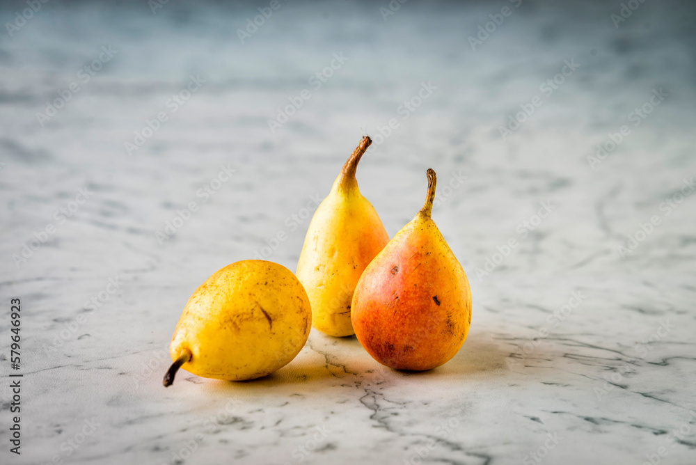 Three fresh pears on a marble surface Three fresh pears on a marble surface