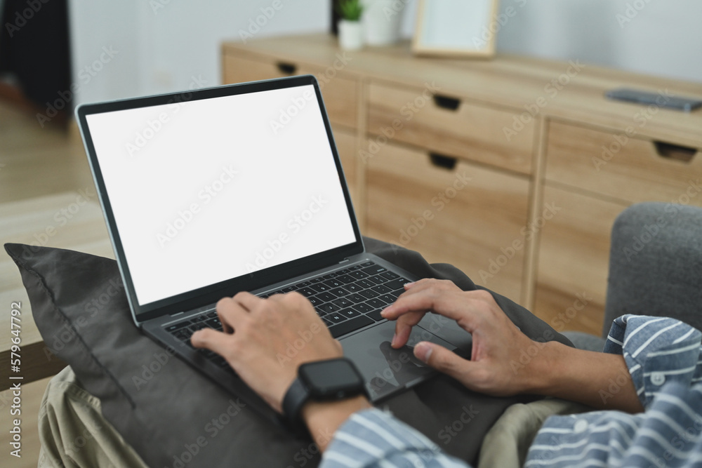 Close up view of man typing on laptop computer with blank white screen. Distance online study and freelance work concept Close up view of man typing on laptop computer with blank white screen. Distance online study and freelance work concept
