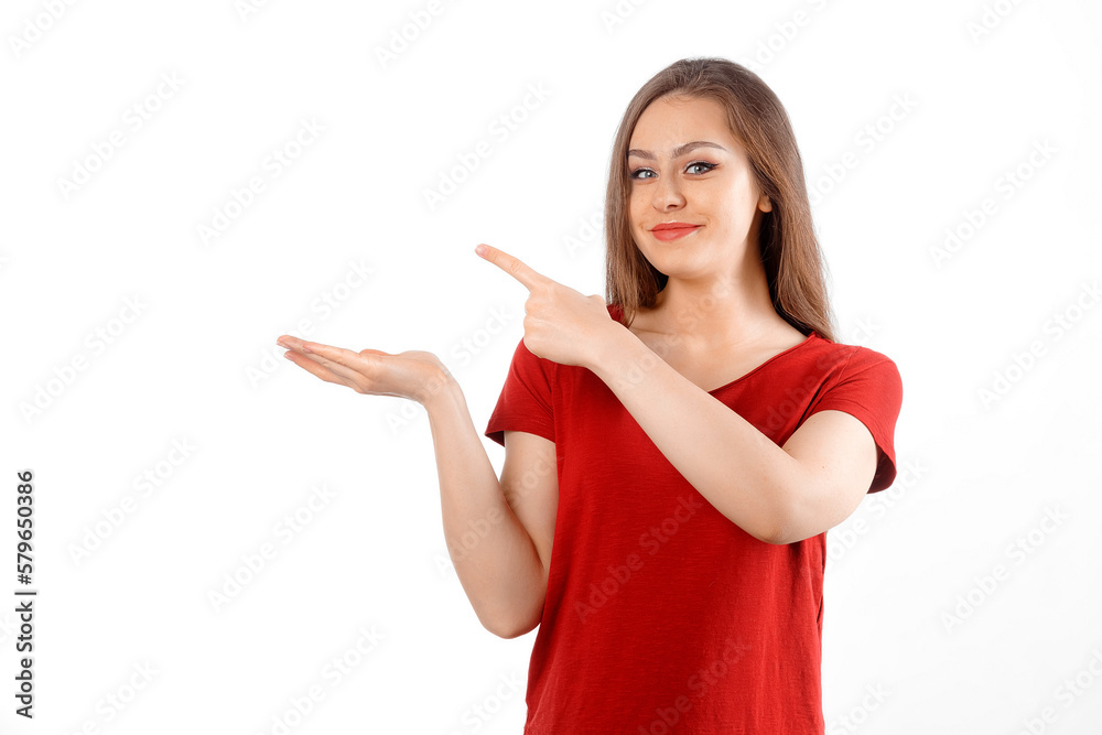 Surprised lovely girl points left at promo banner, shows advertisement on blank white space. Young brunette female looking amazed by promotion offer, stands over white background Surprised lovely girl points left at promo banner, shows advertisement on blank white space. Young brunette female looking amazed by promotion offer, stands over white background