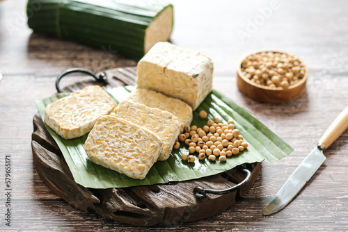 raw tempe or tempeh is a traditional  Indonesian food made from fermented soybeans.. Tempeh wrapped in banana leaf.
