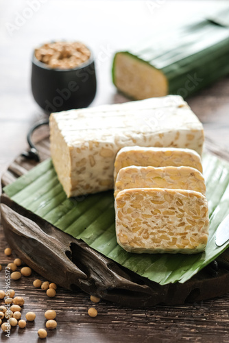 raw tempe or tempeh is a traditional  Indonesian food made from fermented soybeans.. Tempeh wrapped in banana leaf.