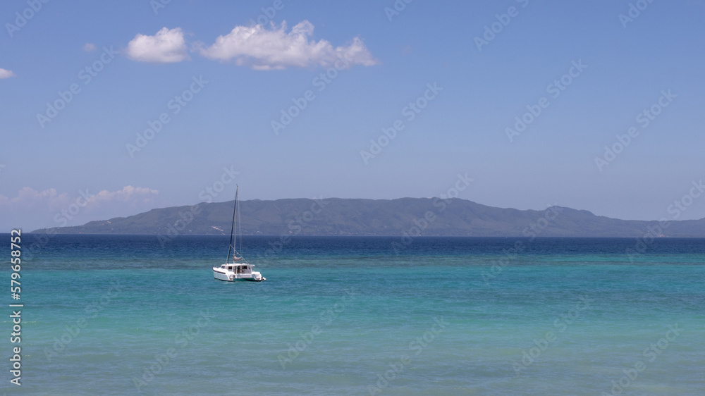 beautiful sea view, with turquoise water and clear, blue sky, a lonely yacht in the sea