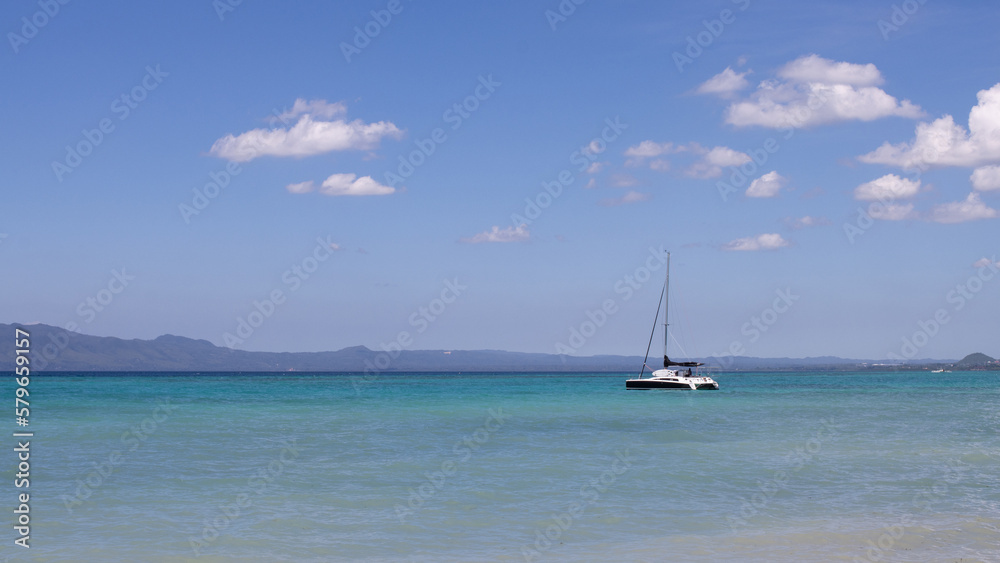 beautiful sea view, with turquoise water and clear, blue sky, a lonely yacht in the sea