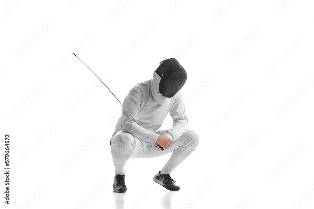 Full-length portrait of sportive man, professional fencer in fencing costume and protective helmet mask have rest isolated on white studio background.