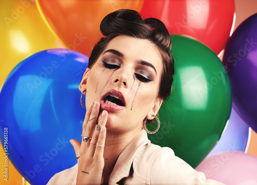 Woman, balloon and sad cry in studio with makeup tears, depression or anxiety at birthday. Mental health model, party or depressed by balloons, frustrated mascara crying or moody with stress at event