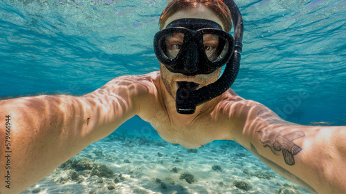 young man snorkeling and taking a selfie in the great barrier reef