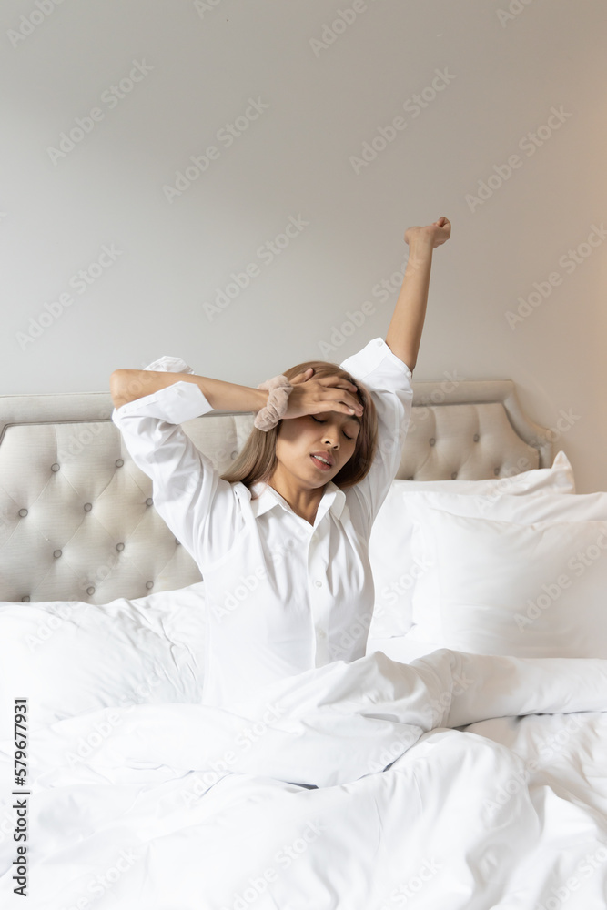 Samolepka Tired and sick Asian woman with colored hair waking up with headahce and stretch