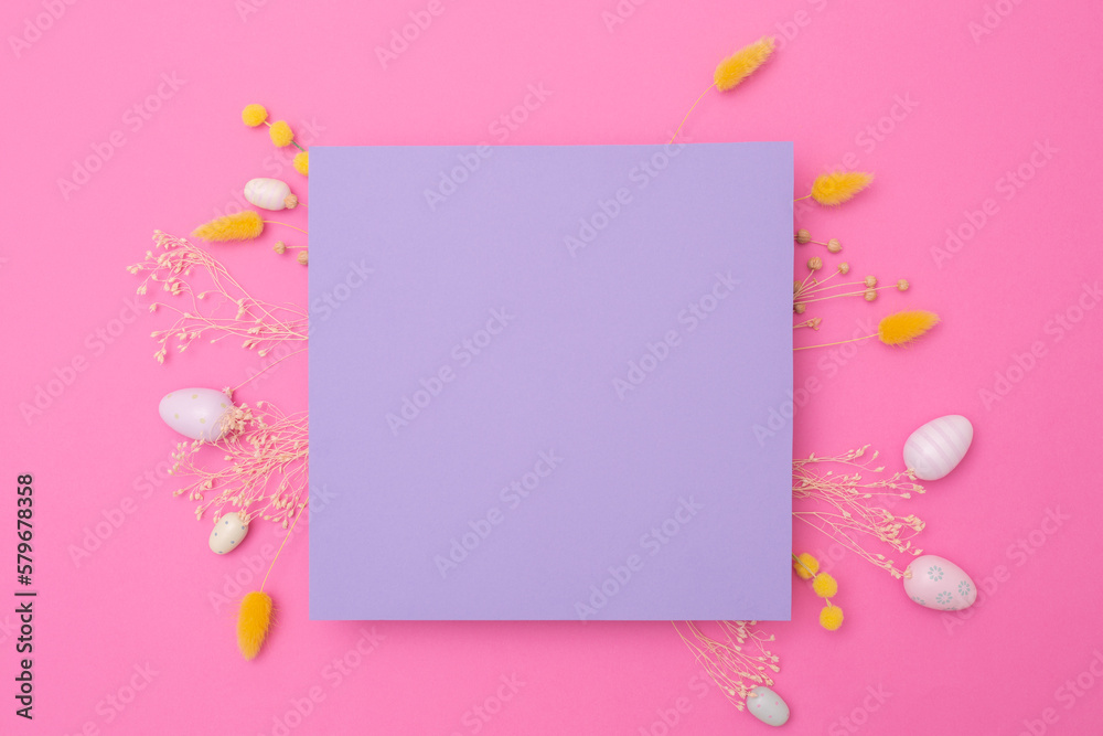 Happy Easter. Empty viola paper with arrangement of Easter eggs and spring dried flowers on pink background. Mockup of cards.