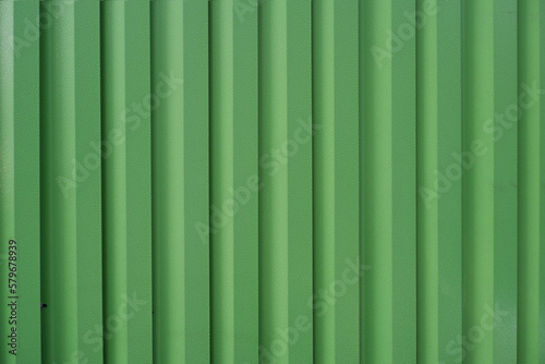 green colored metal fence. Green stripe wallpaper. stripe surface material.