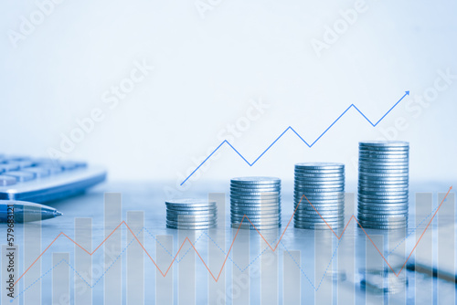 Stack of money coin with graph. Business and finance background concept with blue filter.