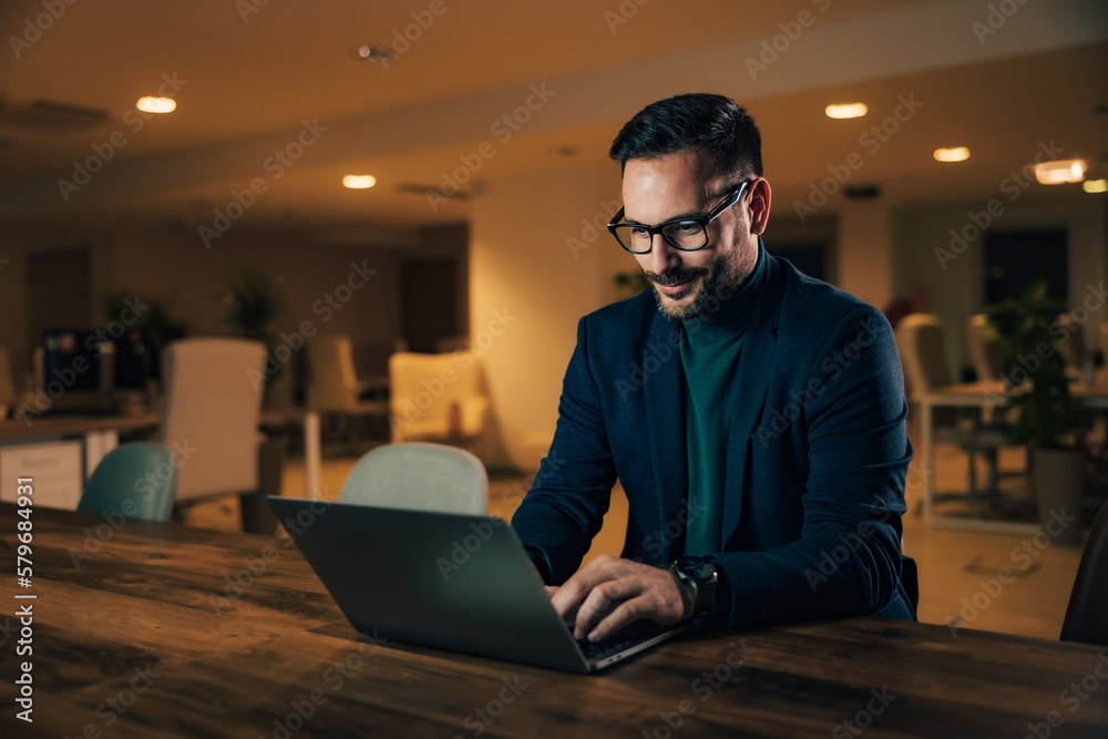 Adult businessman using a laptop at the office, elegantly dressed. Adult businessman using a laptop at the office, elegantly dressed.