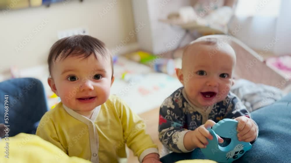 Twin baby connection. children baby have fun with toys on the sofa. Cute moments, the twins baby play in the room on the couch. Double naughty: twins baby play and laugh on fun the couch Twin baby connection. children baby have fun with toys on the sofa. Cute moments, the twins baby play in the room on the couch. Double naughty: twins baby play and laugh on fun the couch