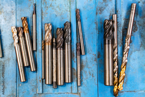 Used drill bits on the lathe rusty metal blue background