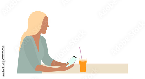 Portrait of young Caucasian woman sitting at table with glass of orange juice, holding smartphone isolated on white background