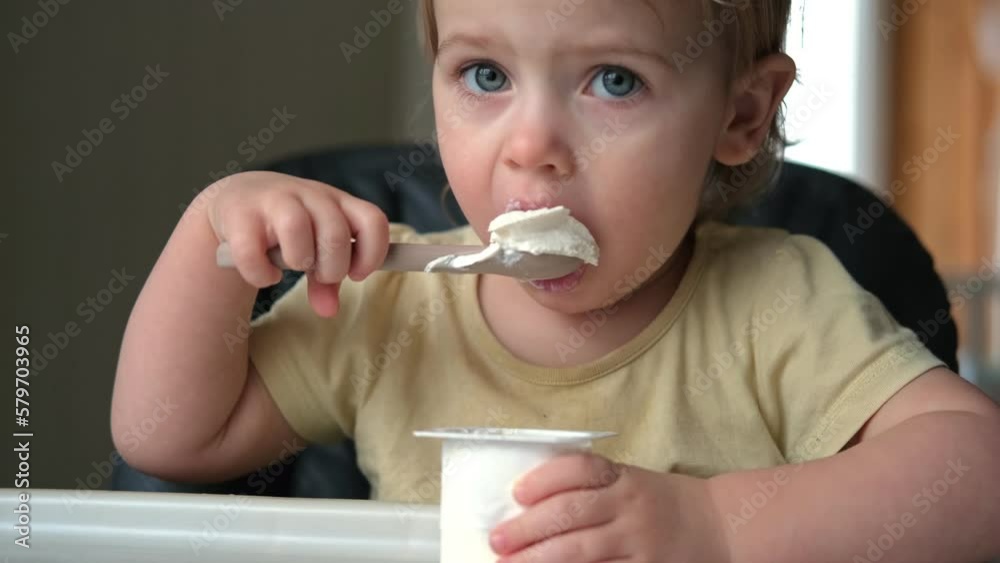 Young Kid Eating Blend Mashed Feed Sitting in High Chair. Baby Weaning