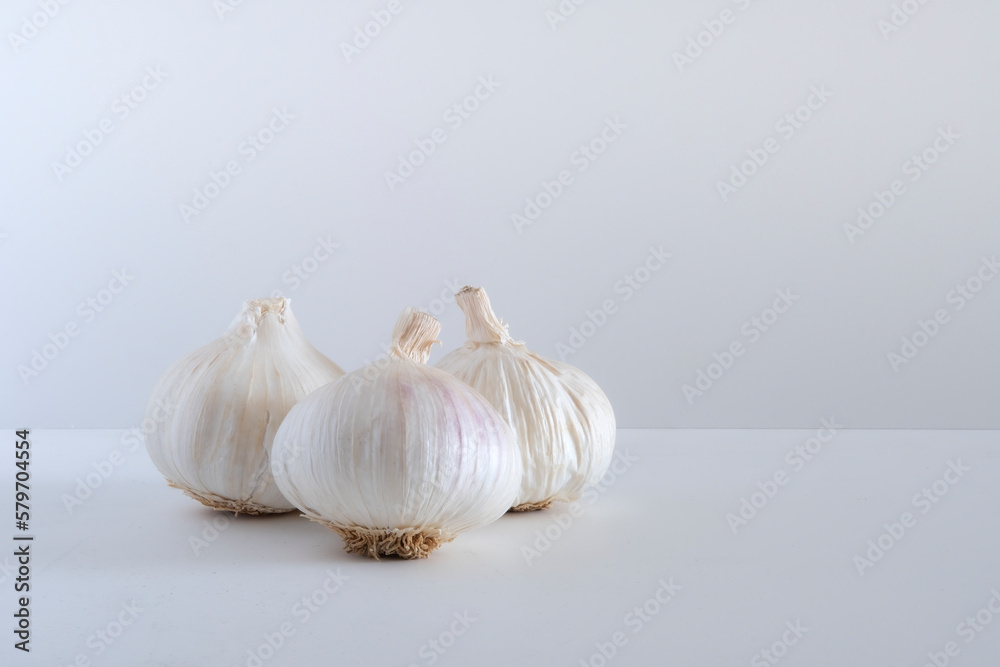 Obraz premium Three garlic and garlic cloves isolated on a white background