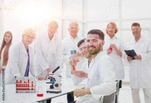 smiling scientist sitting at a laboratory table .