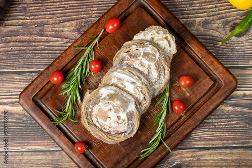 Kokorec. Uncooked kokorec on a wooden serving board. Turkish cuisine delicacies. A dish made from sheep gut. Top view photo