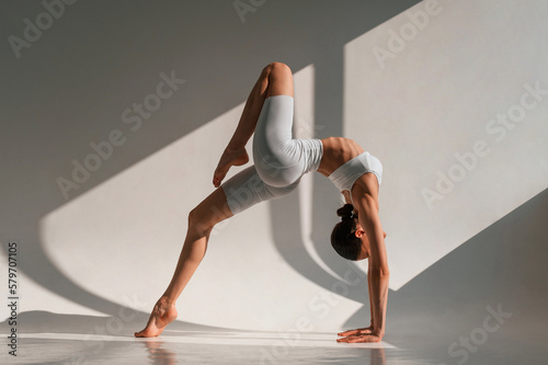 Nice flexible body. Young caucasian woman is indoors in the studio
