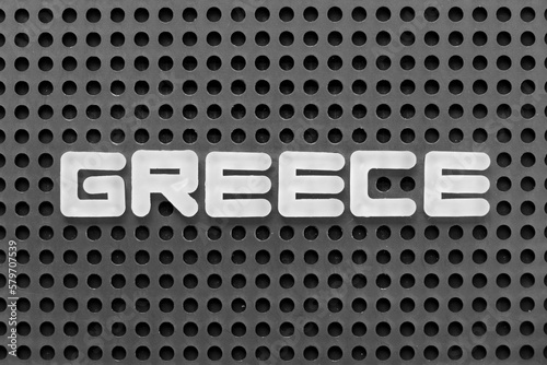 White alphabet letter in word greece on black pegboard background