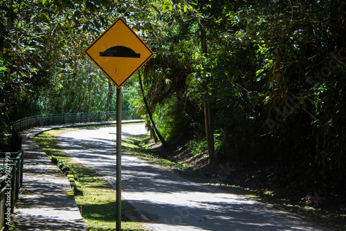 Road cautionary sign indicating speed breaker ahead. Sign indicating to slowdown as speed bump in road photo