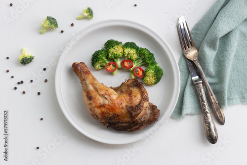 Healthy food grilled chicken has broccoli vegetable in plate on white wood table.