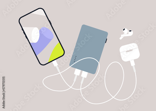 A power bank device and gadgets connected with cables, isolated on a plain background