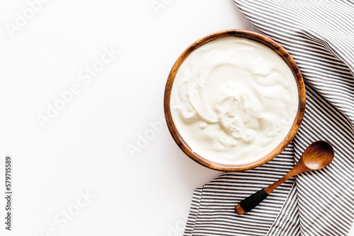 Sour cream or yogurt in wooden bowl. Dairy product background photo