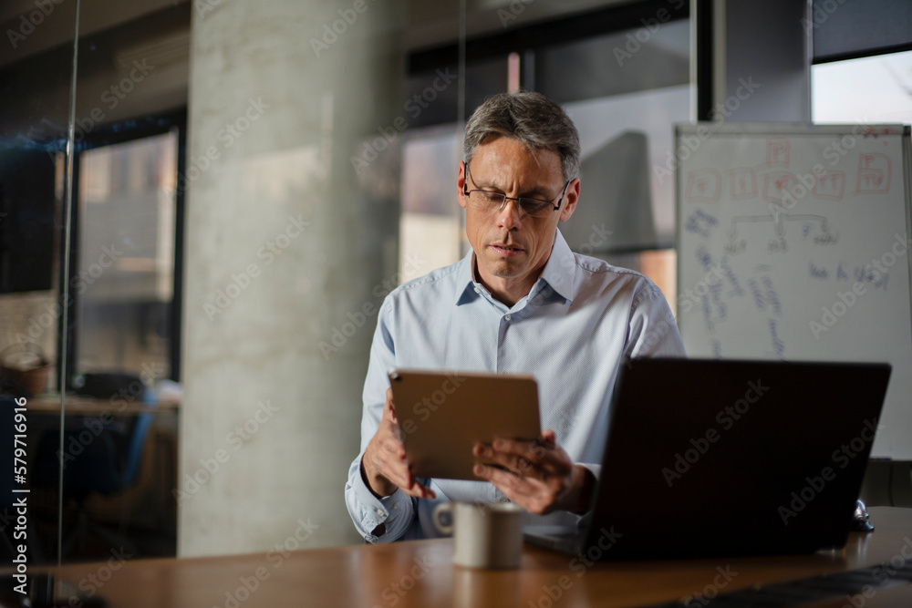 Portrait of businessman in office. Man using digital tablet. Businessman having video call Portrait of businessman in office. Man using digital tablet. Businessman having video call