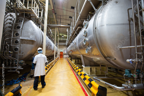 Male work inspection process milk powder cellar at the with horizontal  stainless steel tanks