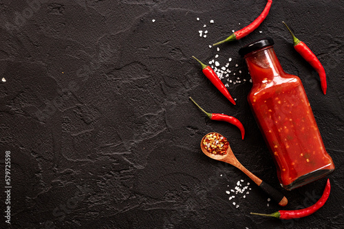 Bottle of spicy sauce tabasco with red hot chili pepper, top view photo