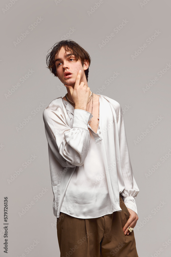Fototapeta premium Fashion portrait of stylish high fashionable boy posing isolated over grey background. Concept of modern fashion, uniqueness, ad