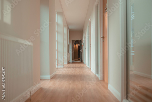 Corridor inside a doctor's surgery, clinic, dental practice or therapy centre. Light interior, hallway with doors and large windows. 