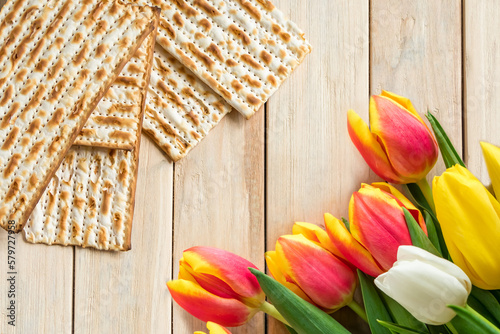 Happy Passover concept. Jewish Regilious holiday Pesach. Tulips and matzo on a light wooden background. photo